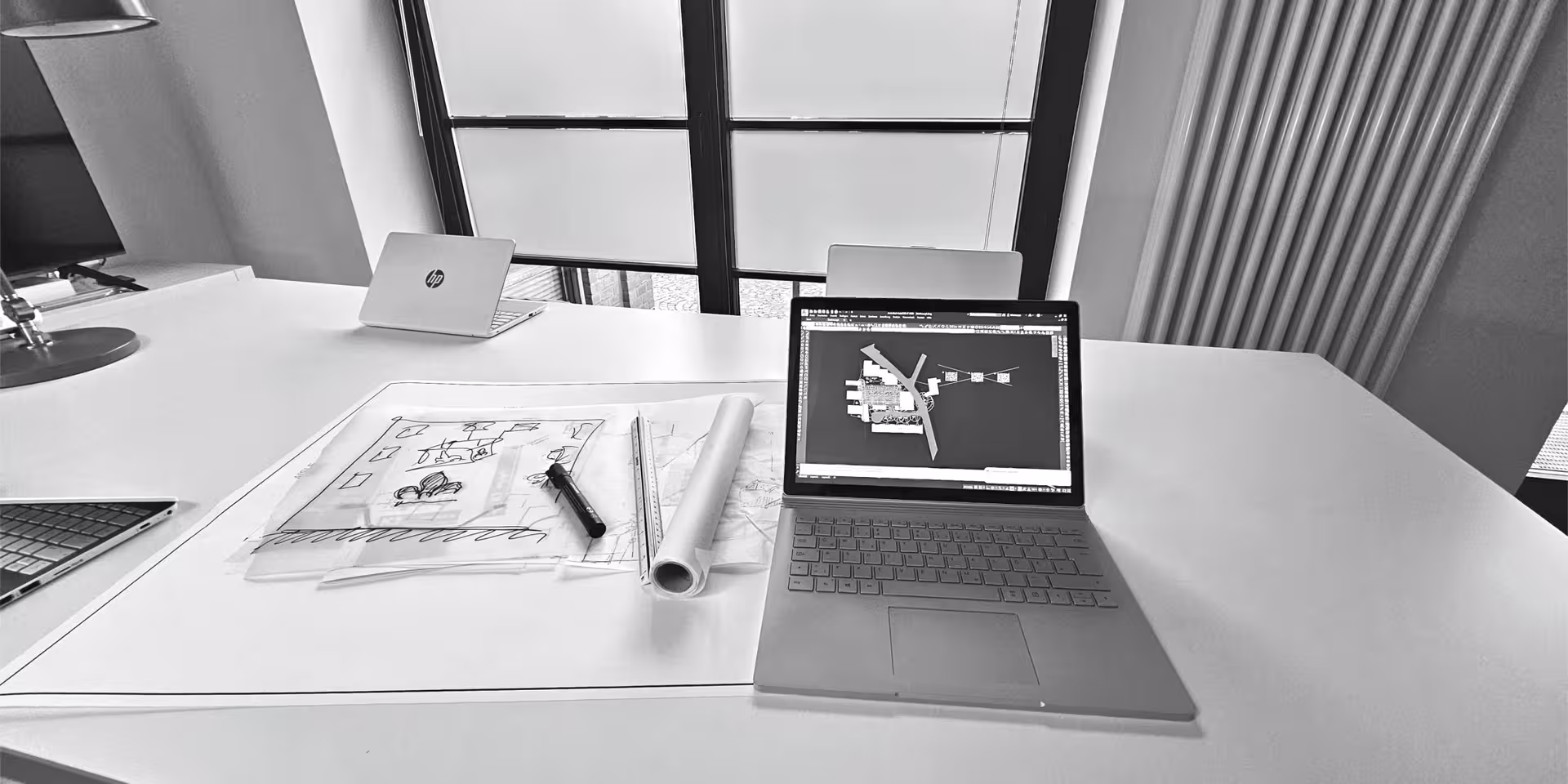 Schreibtisch mit Laptop und Skizzen